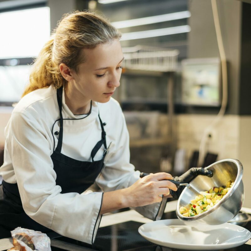 female-chef-pouring-food-plate